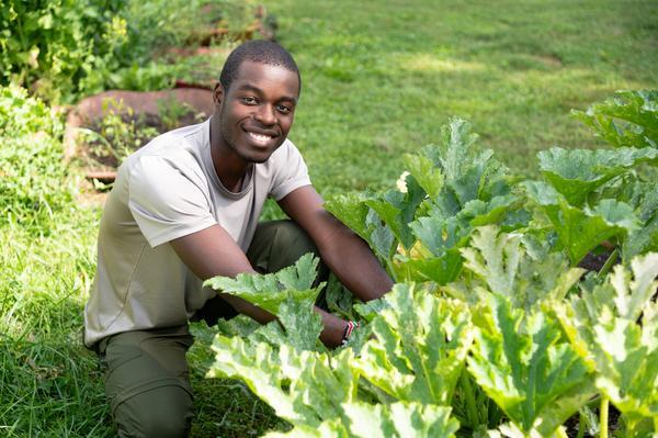 Adrian Zzimbe outside with plants